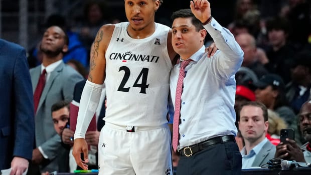 Cincinnati Bearcats guard Jeremiah Davenport (24) takes notes from head coach Wes Miller in the first half of the NCAA basketball game between the Cincinnati Bearcats and the Eastern Kentucky Colonels at Fifth Third Arena in Cincinnati on Sunday, Nov. 13, 2022. Eastern Kentucky Colonels At Cincinnati Bearcats Basketball